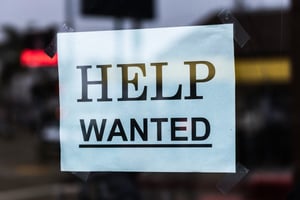 Help Wanted sign taped to the door window