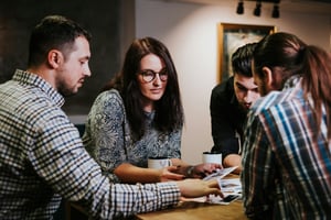 A small business work team around a table in a meeting.