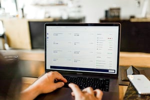 business man looking at a report on his laptop in an office building