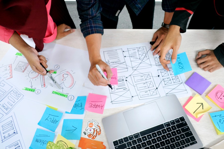 Business team working together around a desk with plans and computer