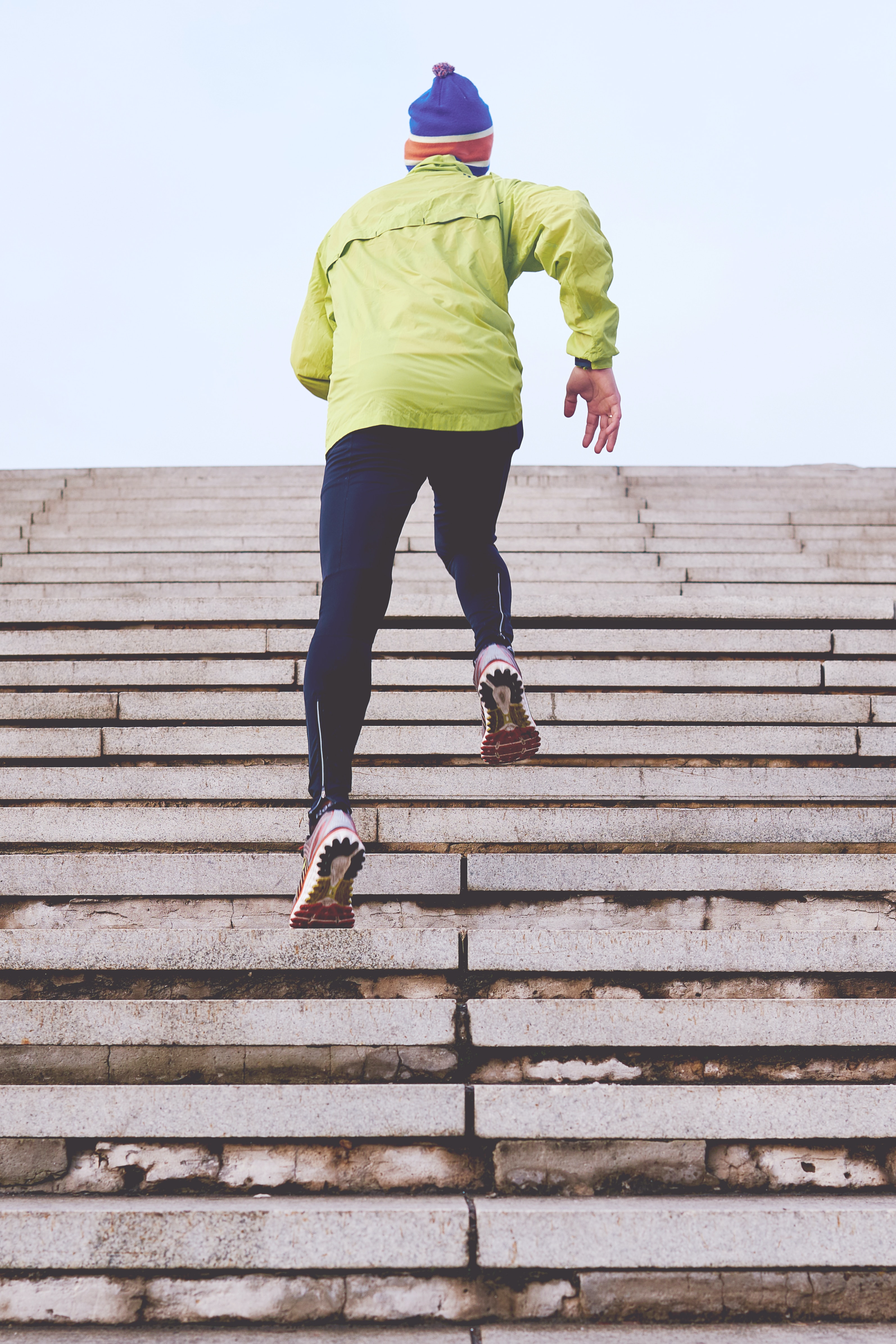 Runner jogging up tall outdoor stairs